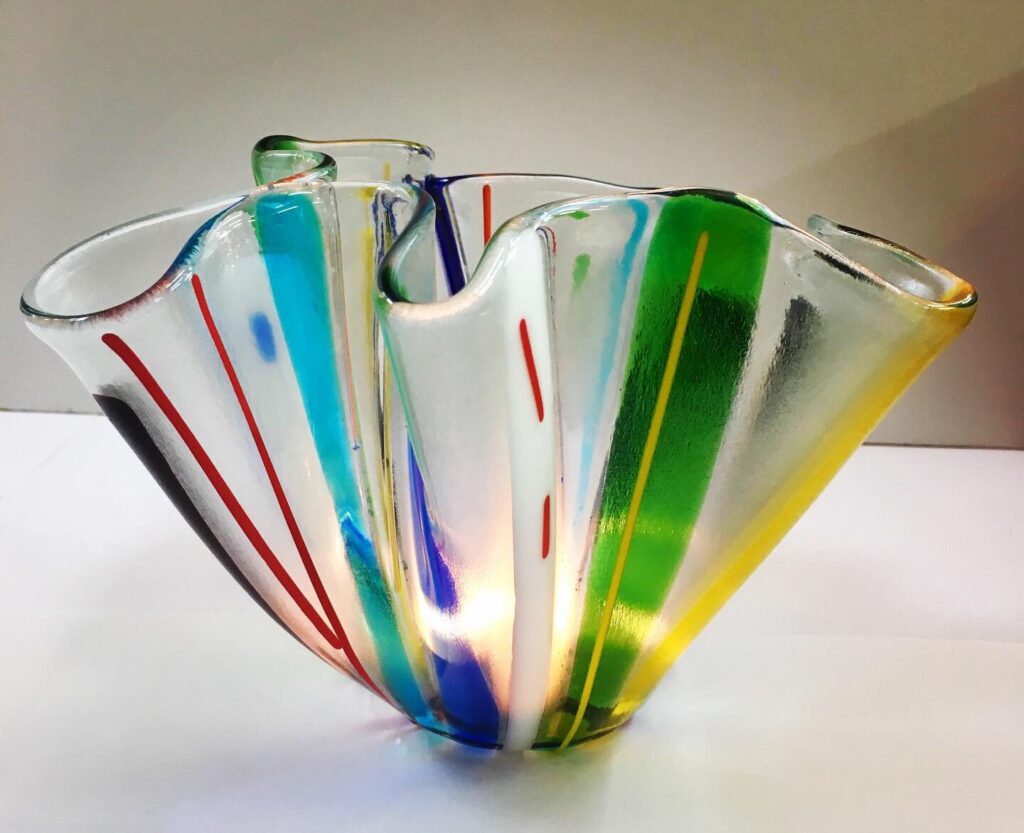 A floral slumped fused glass vase with striped decoration made at Rainbow Glass Studios on the beginners day class
