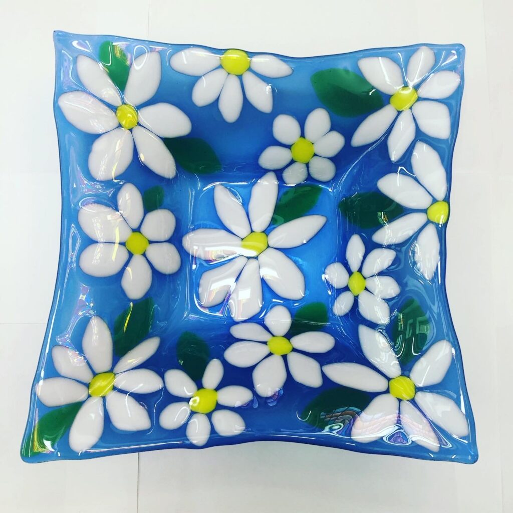 Square "daisy daisy" salad bowl, blue background with shite and yellow daisies and green leaves, a fabulous start for a beginner on our Day Course at Rainbow Glass Studios