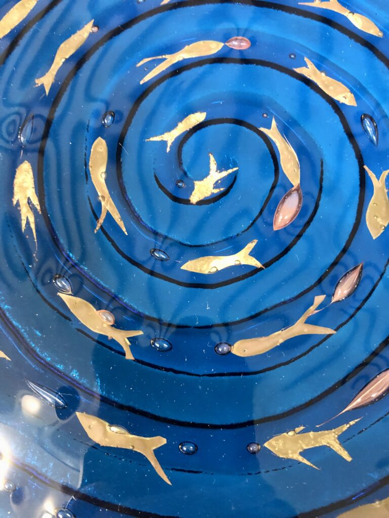 A swirling vortex of fused glass with little brass fishes made by Catherine at one of her first day classes with us at Rainbow Glass Studios