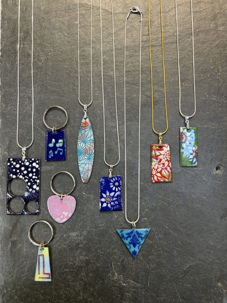 A collection of enamelled jewellery made on the beginners day course in enamelling at Rainbow Glass Studios with Eleanor Watson