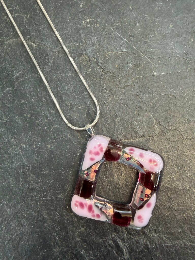 A square donut pendant in pale pink and raspberry fused glass - pretty for the summer! Made at Rainbow Glass Studios on our jewellery day course.