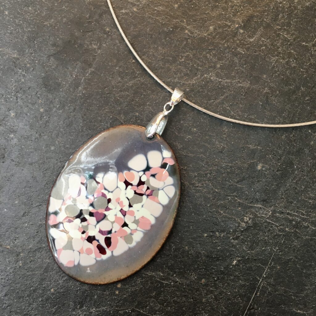 A subtly coloured pendant on a choir, enamelled in grey with glass media to pattern the surface - a beautiful piece made by a student on the enamelling on copper day course
